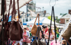 Market stall selling bags with view of shoppers