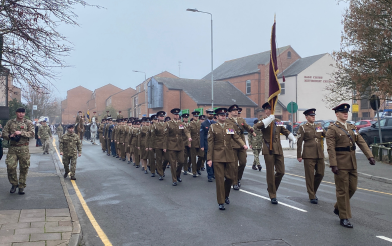 Military personnel marching down Sage Cross Street